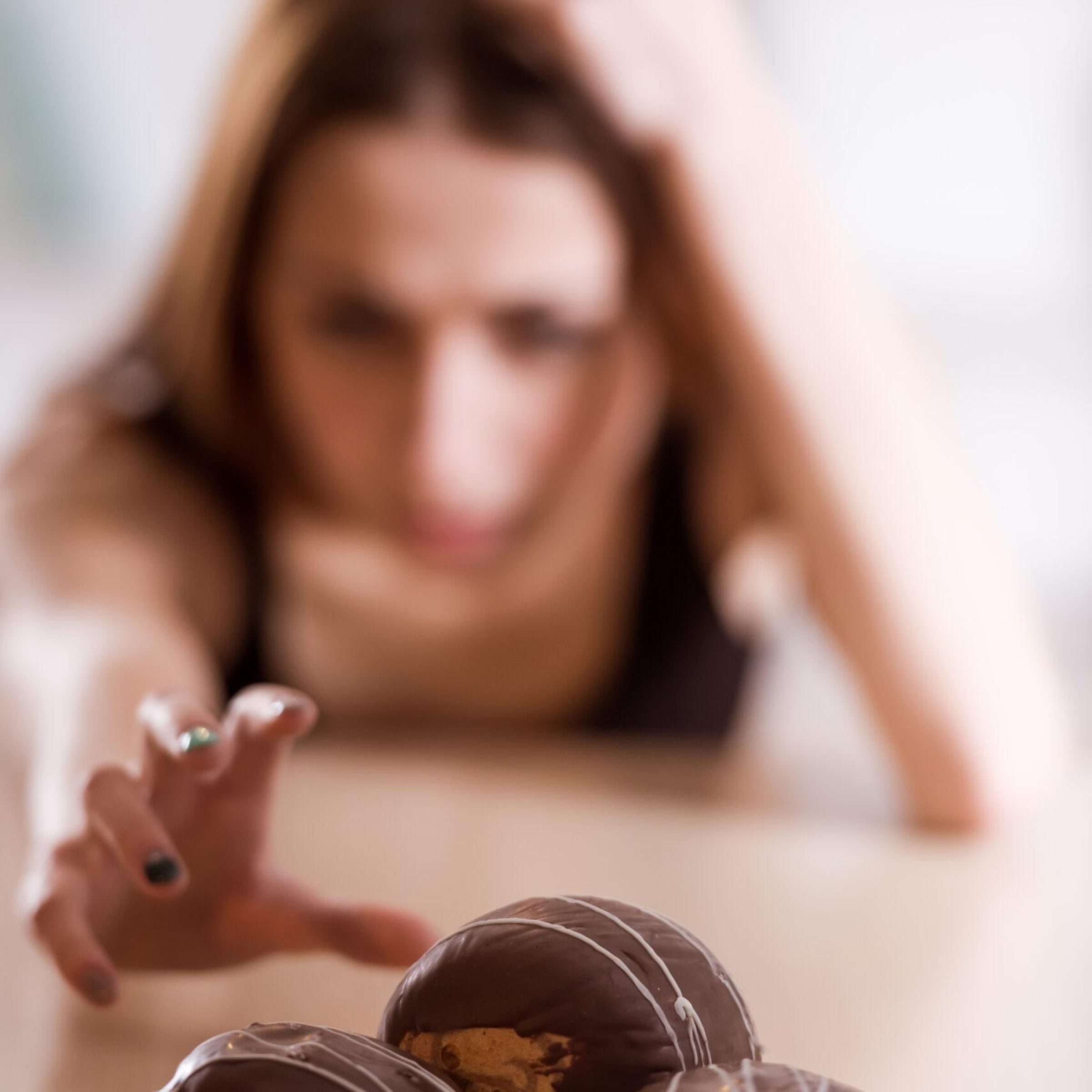 Thin girl refuses sweets that are in the white plate.